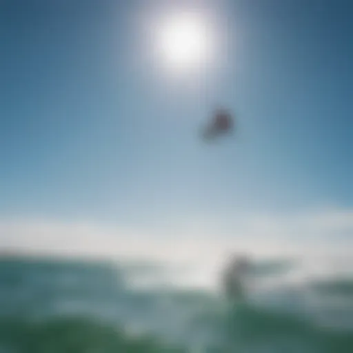 A skilled kiteboarder performing an aerial maneuver against a clear blue sky.