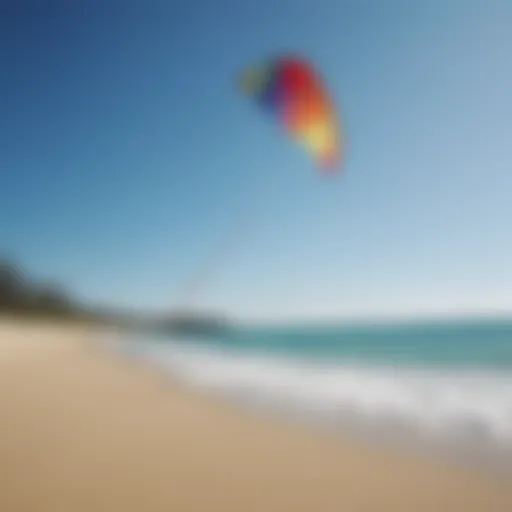 A vibrant, colorful kite soaring in a clear blue sky above a tranquil beach.