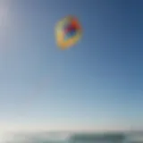 A vibrant kite soaring against a clear blue sky during a kite sailing session.