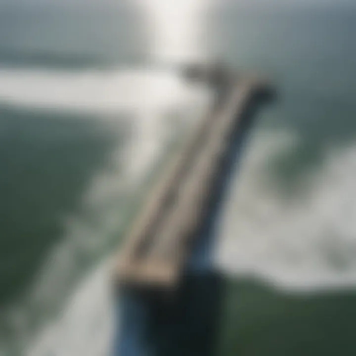 An aerial view of Huntington Beach Pier, highlighting surfers riding waves in the distance.