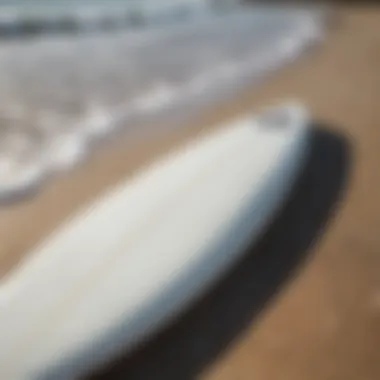 A pristine used Surftech surfboard resting on the beach