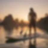 A serene view of a paddle boarder navigating through calm waters at sunrise