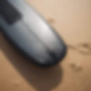 Close-up of a surfboard and wetsuit on the sand