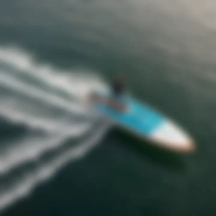 An aerial view of a hydrofoil surfboard gliding above the water, illustrating lift generation in action.